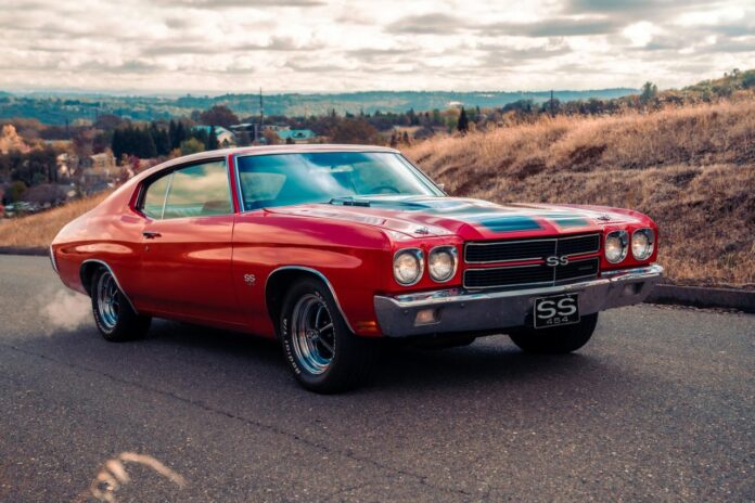 Chevrolet Camaro merah di jalan pada siang hari